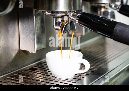 Espresso estratto dalla macchina da caffè nella caffetteria Foto Stock