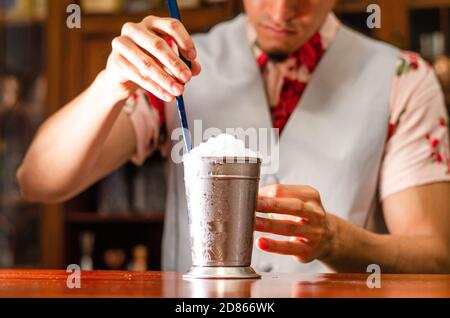 Barista che prepara un delizioso cocktail di julep alla menta al tavolo Foto Stock