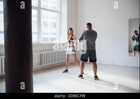 Una giovane vettura attraente di boxing prepara una ragazza graziosa per concorrenza Foto Stock