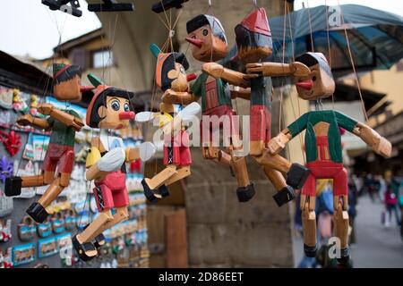 Firenze, Toscana, Italia: Bancarella di strada con i tradizionali souvenir in legno di Pinocchio dalla Toscana, Italia Foto Stock