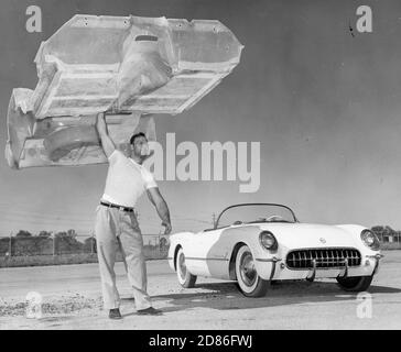 Un uomo tiene in alto il corpo della Corvette sportiva auto da Chevrolet. La sua struttura leggera ma robusta è resa possibile con la fibra di vetro, Detroit, MI, 1958. (Foto di Chevrolet/RBM Vintage Images) Foto Stock
