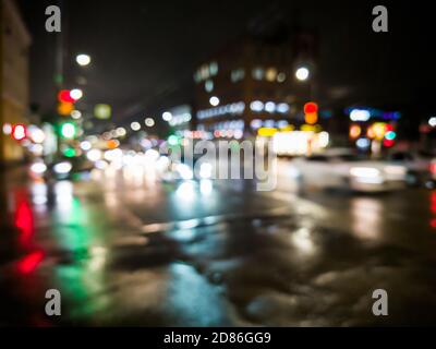 notte defocused pioggia città vista strada con auto che attraversano la strada Foto Stock