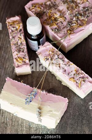 Sapone fatto in casa, fatto di oli vegetali, decorato con petali di rosa e lavanda Foto Stock