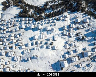 Vista aerea dei tetti innevati sui tradizionali chalet del villaggio delle alpi svizzere. Foto Stock