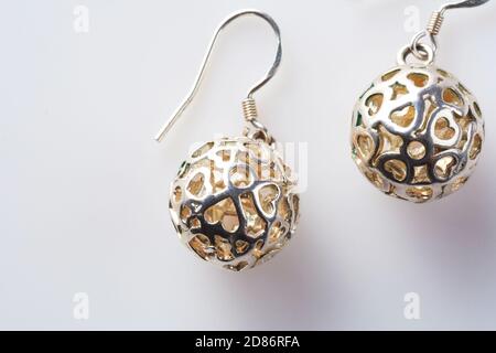 Coppia di orecchini in madreperla rotondi in forma di palline con cuori su sfondo bianco. Moda Orecchini donna in argento Foto Stock