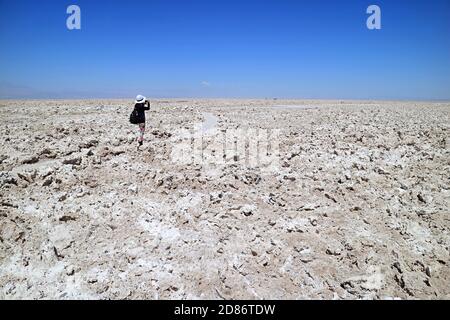 Viaggiatore femminile scattare foto sul sentiero di Salar de Atacama, vasto piatto di sale cileno all'altitudine di 2,305 M. nella regione di Antofagasta, Cile Foto Stock