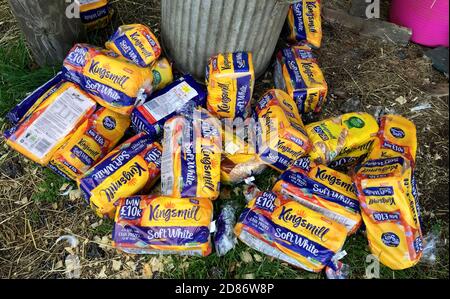 un sacco di pani scartati di pane affettato accanto a bidoni spazzatura. Inghilterra, Isola di Wight Foto Stock