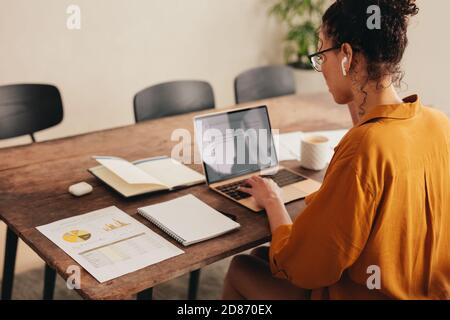Donna che lavora in remoto su un notebook. donna d'affari che lavora da casa durante la pandemia. Foto Stock