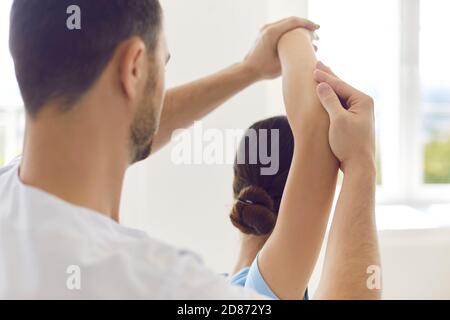 Chiropractor autorizzato o fisioterapista che aiuta la giovane donna durante la riabilitazione fisica Foto Stock