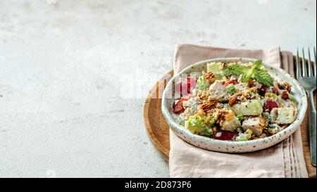 Insalata di Waldorf con spazio fotocopie. Insalata di frutta e noci americane con mele, sedano, uva, carne di pollo, maionese condita. Piatto artigianale con insalata waldorf pronta su fondo grigio di cemento. Banner Foto Stock