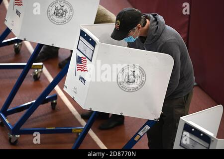 New York City, Stati Uniti. 27 Ott 2020. Un uomo si trova dietro una cabina di privacy degli elettori mentre compila il suo scrutinio per essere lanciato nelle elezioni presidenziali del 2020, all'interno del Park Slope Armory YMCA il quarto giorno delle prime votazioni, nel quartiere Brooklyn di New York City, NY, 27 ottobre 2020. Un numero record di persone in tutti gli Stati Uniti si è espresso a votare nelle elezioni anticipate. (Anthony Behar/Sipa USA) Credit: Sipa USA/Alamy Live News Foto Stock