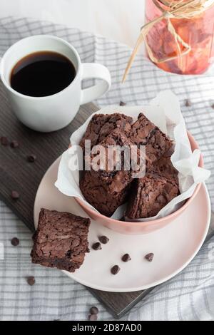 Brownie di cioccolato fresco chewy in ciotola rosa con tazza di caffè Foto Stock