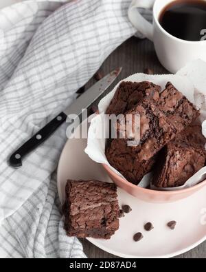 Brownie di cioccolato fresco chewy in ciotola rosa con tazza di caffè Foto Stock