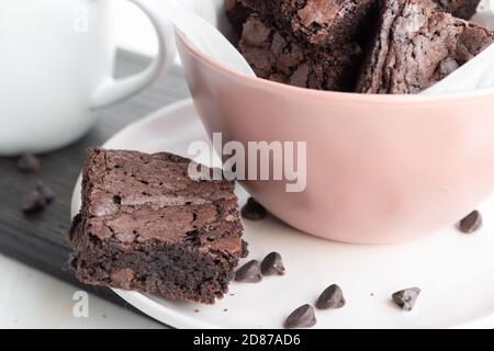 Brownie di cioccolato fresco chewy in ciotola rosa con tazza di caffè Foto Stock