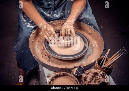 Creazione di un vaso o vaso. Crock master. Preparazione della caraffa in argilla. Lo scultore del laboratorio crea una caraffa con il guardaroba in terracotta. Ruota di Potter. Ceramica Foto Stock