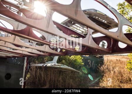 Sole che splende attraverso l'ala della costruzione AN-2 primo piano. Antonov biplano sovietico monomotore abbandonato nel vecchio campo di base aerea, l'aviazione rimane in V. Foto Stock