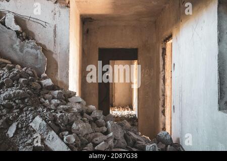 Scalinata in cemento schiacciata all'interno di un pavimento in rovina abbandonato dell'edificio. Città incompiuta di scienziati nucleari a Birky, Ucraina Foto Stock