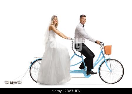 Sposa e sposo che cavalcano una bicicletta in tandem e che guardano telecamera isolata su sfondo bianco Foto Stock