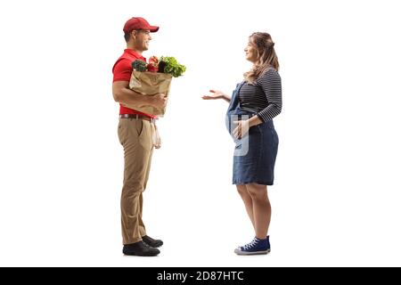 Foto di profilo a lunghezza intera di un tipo di consegna con un borsa della spesa e una donna incinta che ha una conversazione isolata su sfondo bianco Foto Stock