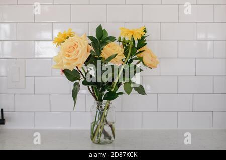 Banco da cucina con fiori gialli in vaso Foto Stock