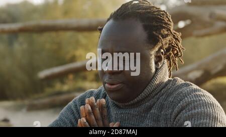 Giovane africano che prega nella natura. Foto di alta qualità Foto Stock