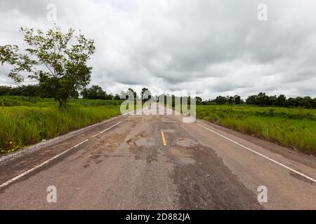 Danneggiato asfalto strada con buche ,Asia Foto Stock