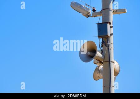 Altoparlante sul polo di illuminazione. Mezzi di avvertimento in caso di emergenza. Contro lo spazio di copia di sfondo blu del cielo Foto Stock