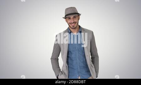 Giovane uomo turistico asiatico che indossa cappello che cammina con le mani dentro tasca Foto Stock