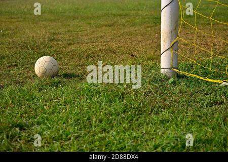 Pallone da calcio adagiato sull'erba verde accanto al calcio obiettivo Foto Stock
