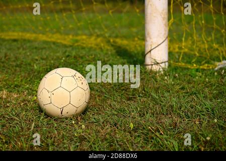 Pallone da calcio adagiato sull'erba verde accanto al calcio obiettivo Foto Stock