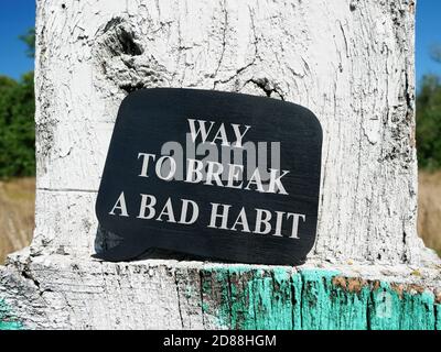 Modo di rompere un cattivo segno di abitudine sul piatto nero. Foto Stock
