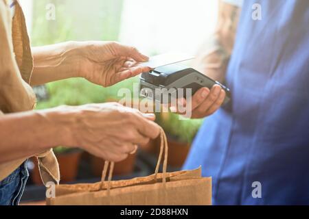 Pagamento senza contatto tra uomo e donna Foto Stock