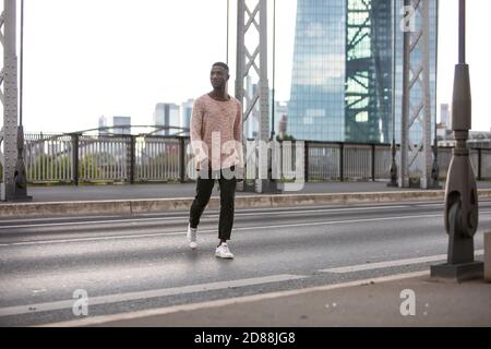 Uomo che attraversa la strada con la testa girata a lato. Scatto lungo. Foto Stock