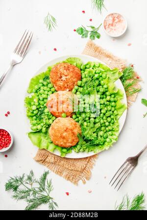 Polpette di pesce o cotolette di merluzzo con verdure verdi, vista dall'alto Foto Stock