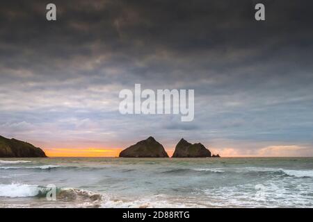 Tramonto a Holywell Beach con Gull Rocks in lontananza in Cornovaglia. Foto Stock