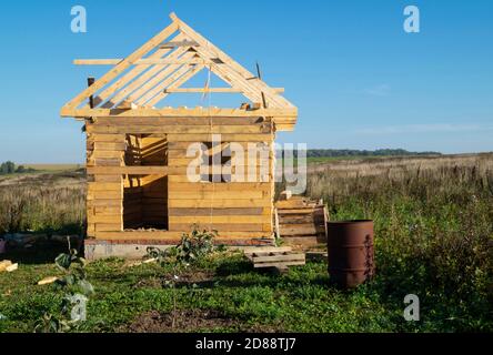 La costruzione dell'edificio in legno da bar su cielo di sfondo. Disegno dall'albero nel campo all'ora del giorno Foto Stock