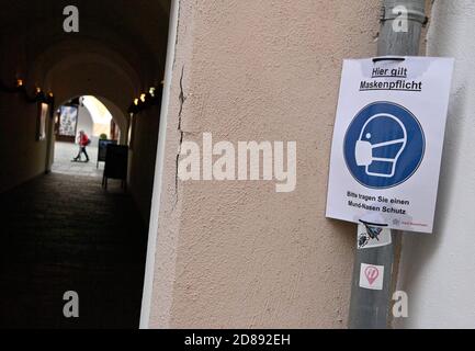 Monaco, Germania. 28 Ott 2020. Un cartello con l'iscrizione 'le maschere sono obbligatorie qui - si prega di indossare un protettore di bocca e naso' è appeso ad un ingresso al centro della città. Credit: Peter Kneffel/dpa/Alamy Live News Foto Stock