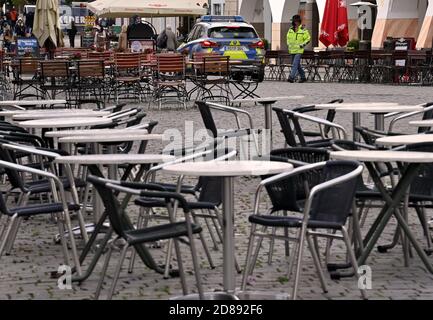 Monaco, Germania. 28 Ott 2020. Una macchina di polizia passa davanti a caffetterie vuote nella zona pedonale. Credit: Peter Kneffel/dpa/Alamy Live News Foto Stock