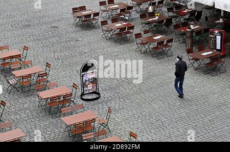 Monaco, Germania. 28 Ott 2020. Un uomo cammina tra ristoranti vuoti nella zona pedonale. Credit: Peter Kneffel/dpa/Alamy Live News Foto Stock