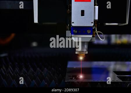 testa di taglio laser durante il taglio della lamiera con la luce di accensione in fabbrica Foto Stock