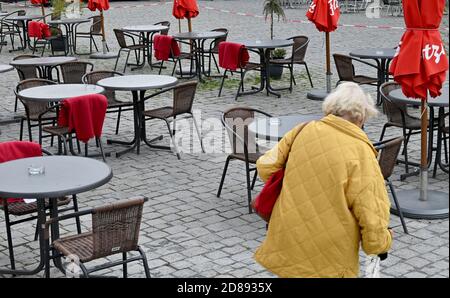 Monaco, Germania. 28 Ott 2020. Una passeggiata pedonale passa davanti a un caffè vuoto nella zona pedonale. Credit: Peter Kneffel/dpa/Alamy Live News Foto Stock