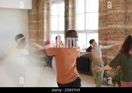 Eccitato l'uomo africano che balla insieme ad altri giovani sala da ballo Foto Stock