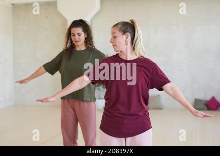 Giovane donna che insegna alla giovane ballerina a ballare durante l'allenamento presso la sala da ballo Foto Stock