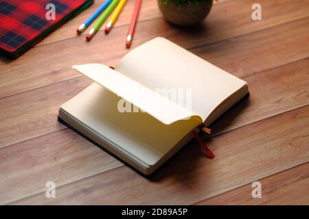 apri il libro e una matita su un tavolo di legno Foto Stock