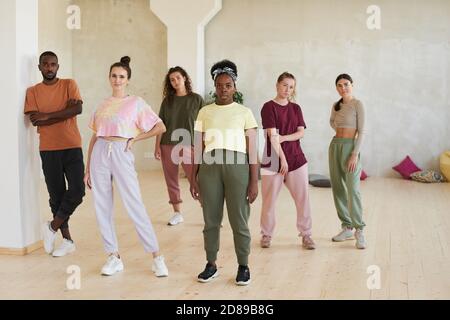 Ritratto di una squadra di giovani ballerini che guarda la macchina fotografica mentre in piedi in studio di danza Foto Stock