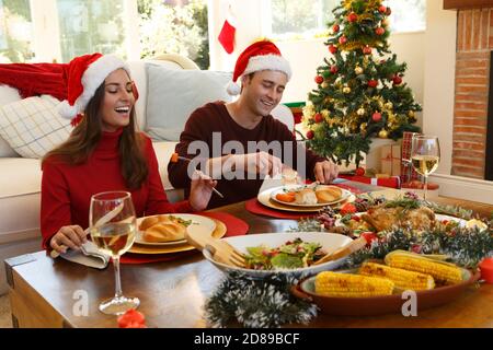 Coppia seduta e pranzo insieme mentre si siede nella soggiorno a casa Foto Stock