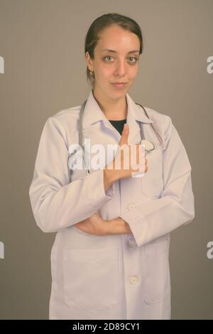 Giovane bella donna medico contro uno sfondo grigio Foto Stock