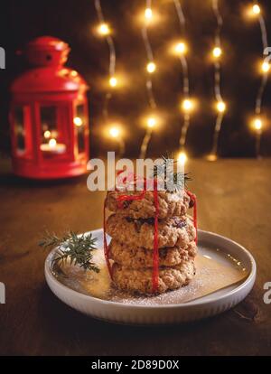 biscotti salutari di farinata d'avena con bacche secche sullo sfondo di una terra ardente. Cottura fatta in casa. Atmosfera natalizia Foto Stock