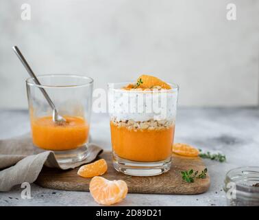 Dolce sano fatto in casa, yogurt e chia con frutta fresca. Sfondo grigio chiaro. Foto Stock