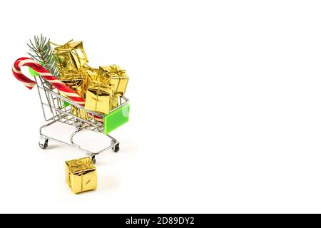 Piccolo supermercato cart riempito con regali di Natale isolato su sfondo bianco. Concetto di shopping di cristmas. Spazio di copia Foto Stock